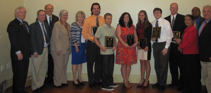 Scholarship recipients holding plaques.